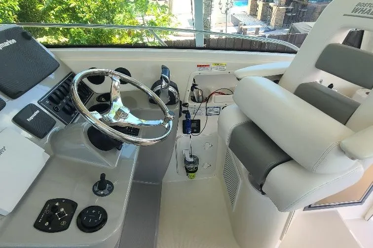 The Snapper Slapper Yacht Photos Pics Cockpit of 2014 Boston Whaler 315 Conquest Pilothouse with steering wheel and controls.