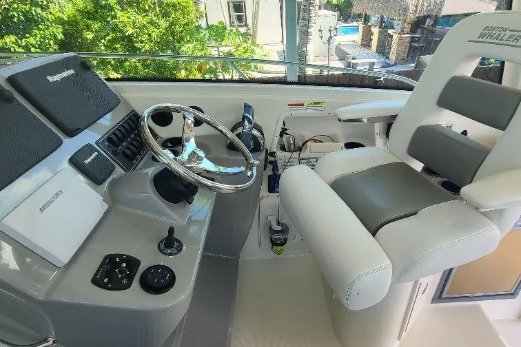 The Snapper Slapper Yacht Photos Pics 2014 Boston Whaler 315 Conquest Pilothouse helm with steering wheel and captain's chair.