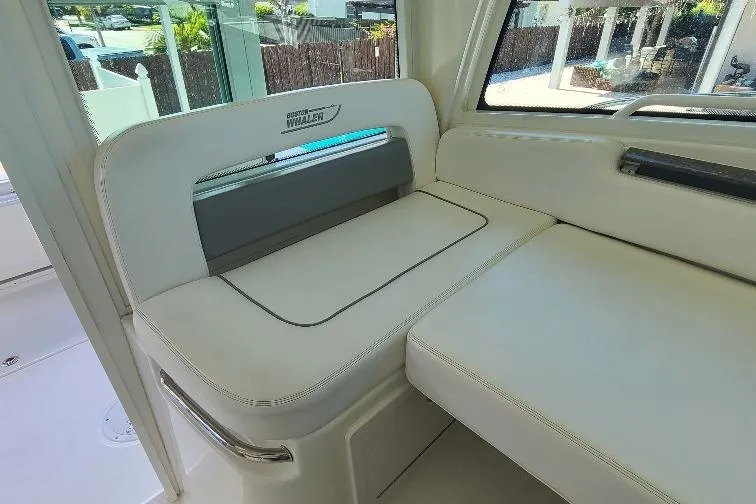 The Snapper Slapper Yacht Photos Pics 2014 Boston Whaler 315 Conquest Pilothouse interior seating, white upholstery, modern design.