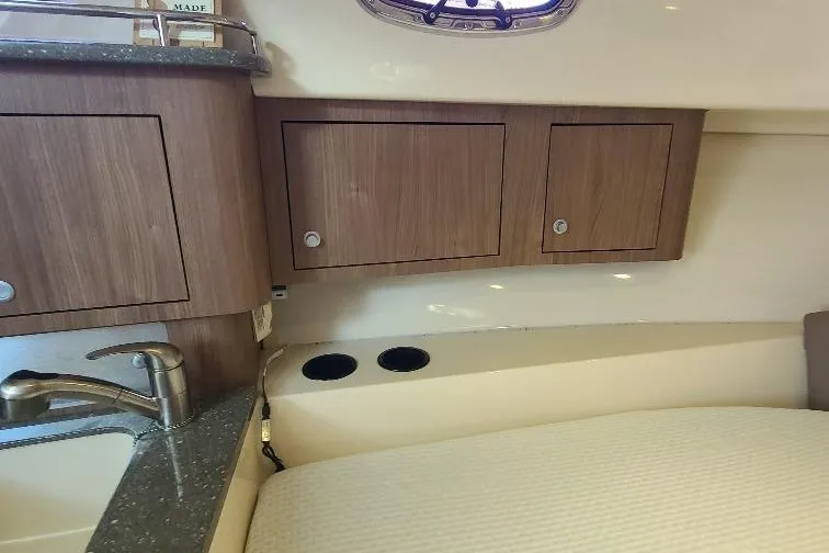 The Snapper Slapper Yacht Photos Pics 2014 Boston Whaler 315 Conquest Pilothouse interior with wood cabinets and sink.
