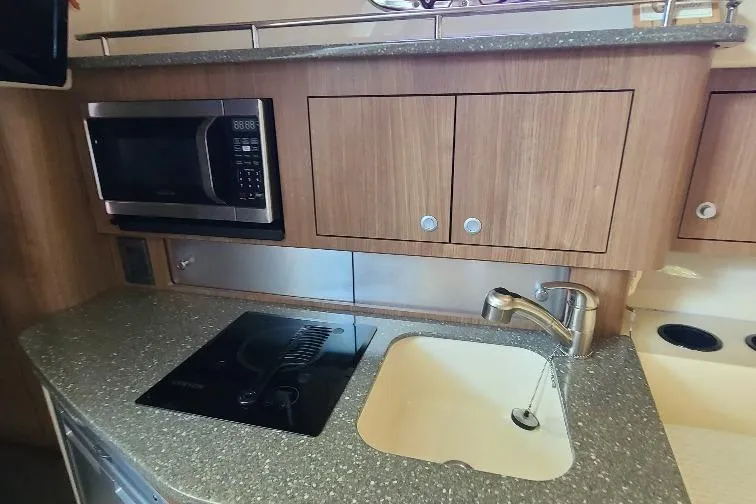 The Snapper Slapper Yacht Photos Pics 2014 Boston Whaler 315 Conquest Pilothouse kitchen with microwave, sink, and stovetop.