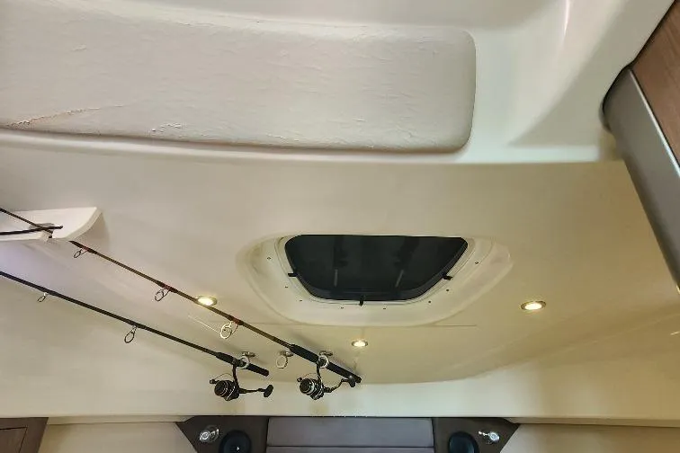 The Snapper Slapper Yacht Photos Pics Interior view of 2014 Boston Whaler 315 Conquest Pilothouse with fishing rods and ceiling hatch.