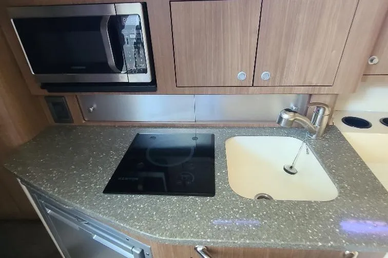 The Snapper Slapper Yacht Photos Pics 2014 Boston Whaler 315 Conquest Pilothouse kitchen with microwave, stovetop, and sink.