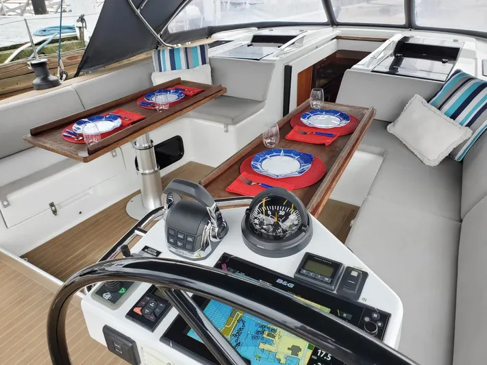 Red's Goose Yacht Photos Pics Luxurious 2016 Hanse 575 yacht cockpit with elegant dining setup and navigation equipment.