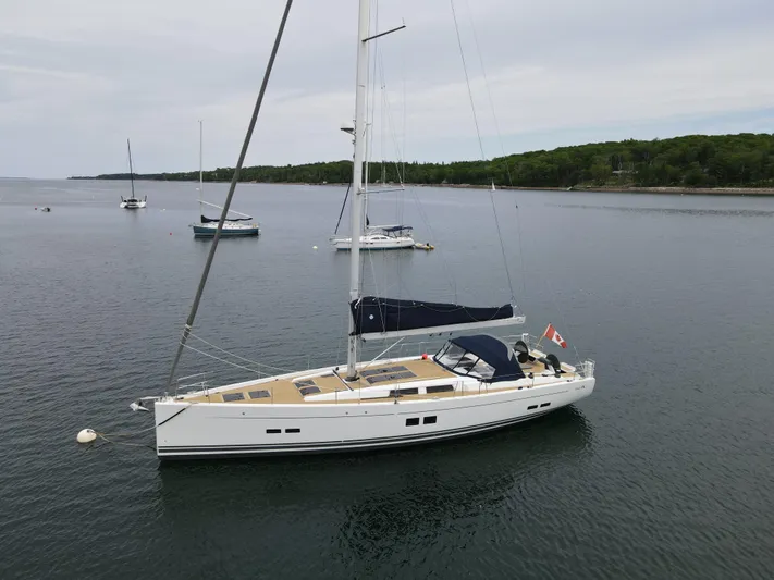 Red's Goose Yacht Photos Pics 2016 Hanse 575 sailboat anchored in calm waters, surrounded by lush greenery.