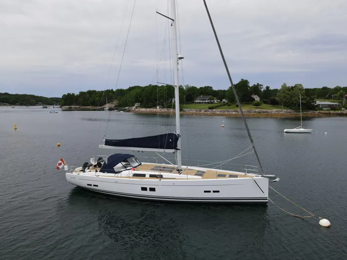 Red's Goose Yacht Photos Pics 2016 Hanse 575 yacht anchored in calm waters with scenic shoreline background.