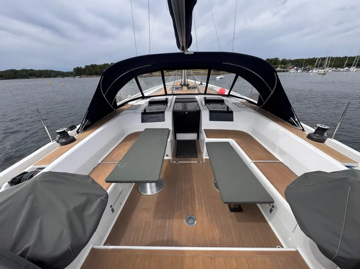 Red's Goose Yacht Photos Pics 2016 Hanse 575 yacht cockpit with seating, table, and canopy on calm water.