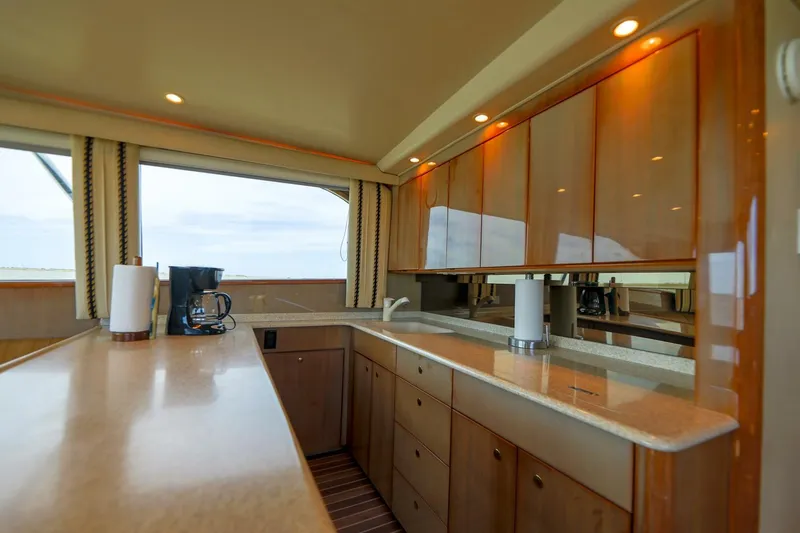 Beer-a-cuda Yacht Photos Pics Luxurious kitchen interior of 2005 Viking 48 Convertible yacht with wooden cabinets.