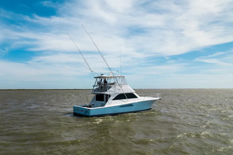 Beer-a-cuda Yacht Photos Pics 2005 Viking 48 Convertible yacht cruising on open water under a blue sky.