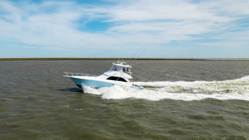 Beer-a-cuda Yacht Photos Pics 2005 Viking 48 Convertible yacht cruising on open water under a clear sky.