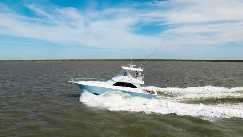Beer-a-cuda Yacht Photos Pics 2005 Viking 48 Convertible yacht cruising on open water under a clear blue sky.