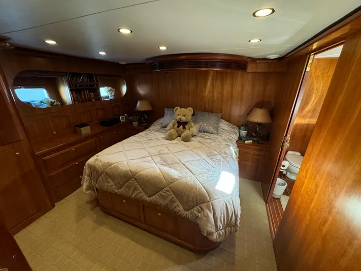 Mariner Yacht Photos Pics Luxurious bedroom in 2006 President 63 Pilot House yacht with wood paneling and plush bedding.