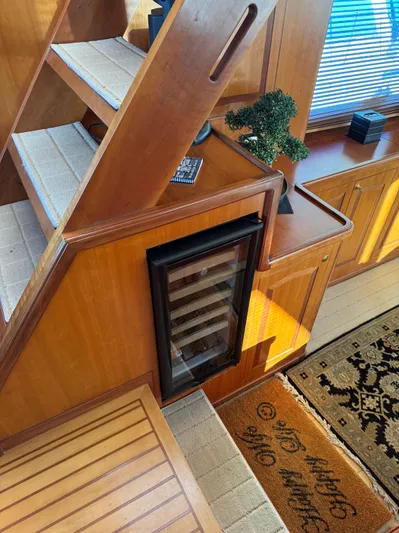 Mariner Yacht Photos Pics Interior of 2006 President 63 Pilot House yacht with wooden stairs and mini fridge.