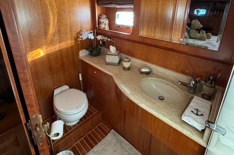 Mariner Yacht Photos Pics Luxurious bathroom in 2006 President 63 Pilot House yacht with wooden cabinetry and elegant fixtures.