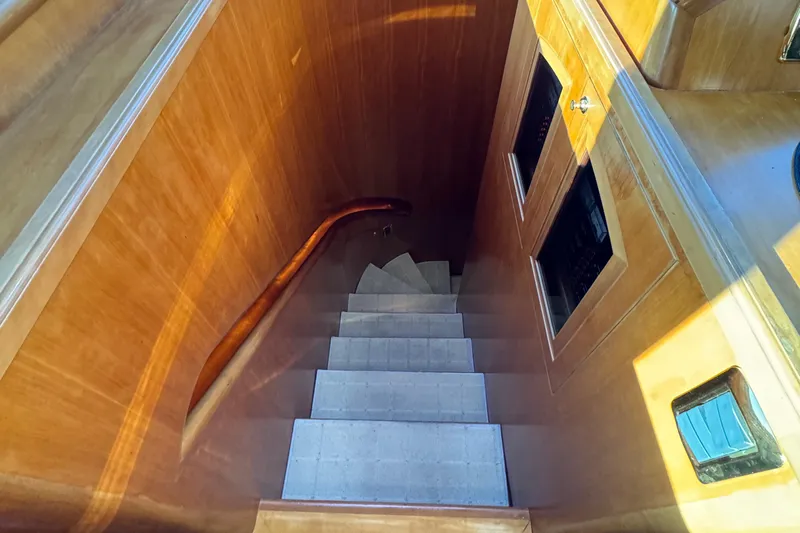 Mariner Yacht Photos Pics Staircase inside 2006 President 63 Pilot House yacht with wooden paneling and handrail.