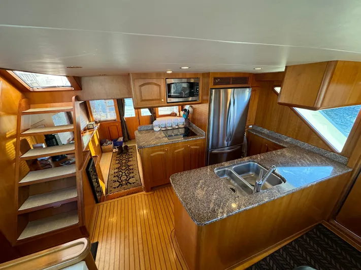 Mariner Yacht Photos Pics Luxurious kitchen interior of a 2006 President 63 Pilot House yacht with wooden cabinetry.