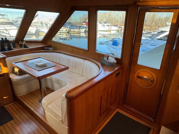 Mariner Yacht Photos Pics Luxurious 2006 President 63 Pilot House interior with elegant wood finish and marina view.