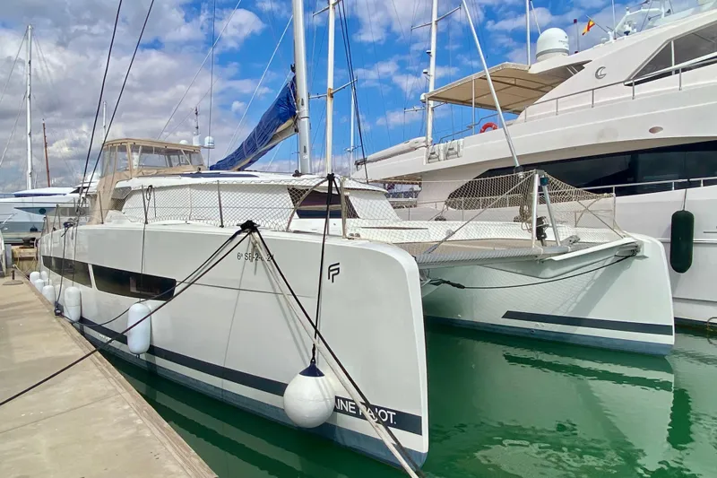  Yacht Photos Pics 2024 Fountaine Pajot Catamaran Aura 51 docked at marina, clear sky background.