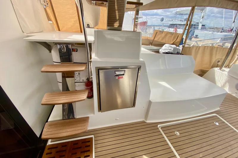  Yacht Photos Pics 2024 Fountaine Pajot Catamaran Aura 51 interior with wooden steps and stainless steel features.