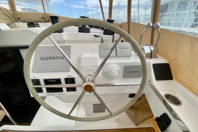  Yacht Photos Pics Steering wheel and controls of 2024 Fountaine Pajot Catamaran Aura 51 with Garmin navigation.
