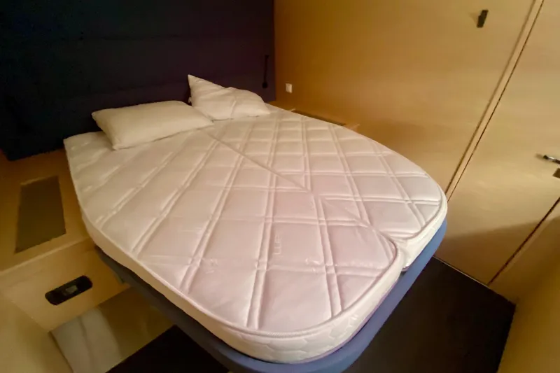  Yacht Photos Pics Luxurious bedroom interior of 2024 Fountaine Pajot Catamaran Aura 51 with comfortable bedding.