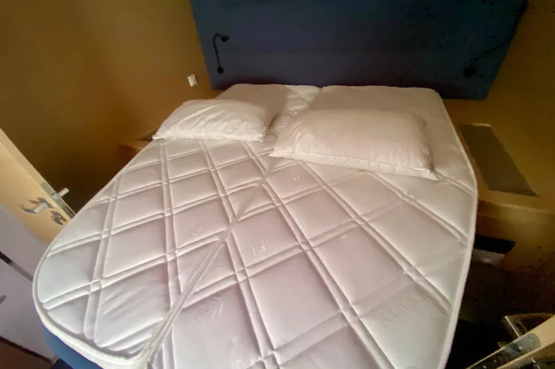  Yacht Photos Pics Luxurious bedroom interior of 2024 Fountaine Pajot Catamaran Aura 51 with plush bedding.