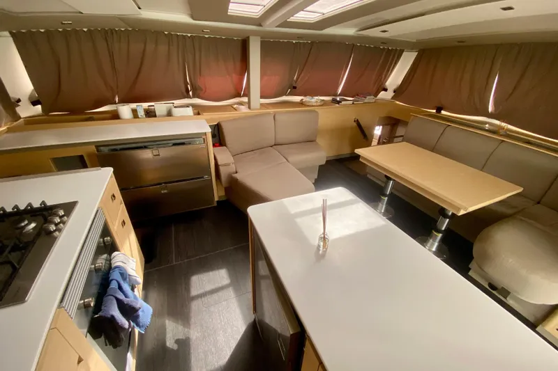  Yacht Photos Pics Luxurious interior of 2024 Fountaine Pajot Catamaran Aura 51 with modern kitchen and seating area.