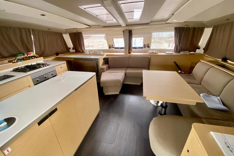  Yacht Photos Pics 2024 Fountaine Pajot Catamaran Aura 51 interior with modern kitchen and cozy seating area.