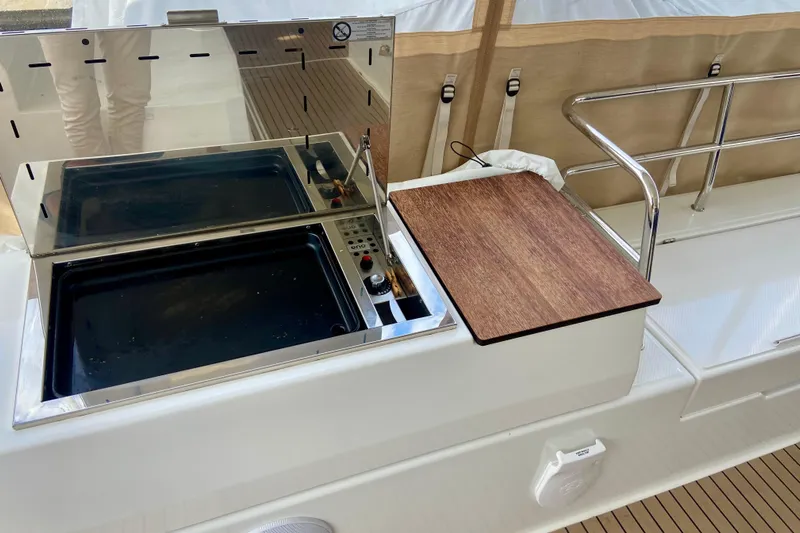  Yacht Photos Pics Outdoor kitchen on 2024 Fountaine Pajot Catamaran Aura 51 with grill and cutting board.