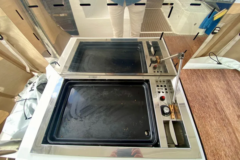  Yacht Photos Pics Modern kitchen setup on 2024 Fountaine Pajot Catamaran Aura 51, featuring a sleek stovetop.