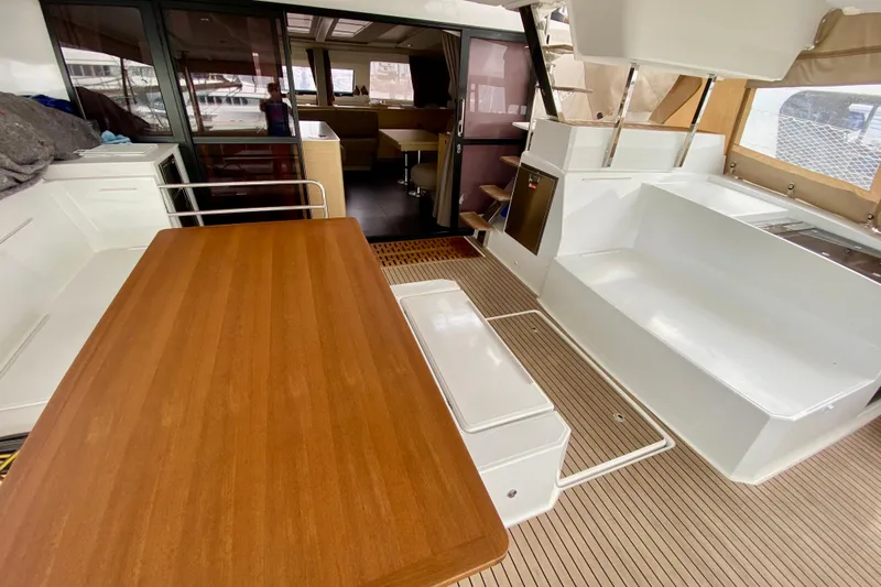  Yacht Photos Pics 2024 Fountaine Pajot Catamaran Aura 51 interior with wooden table and seating area.