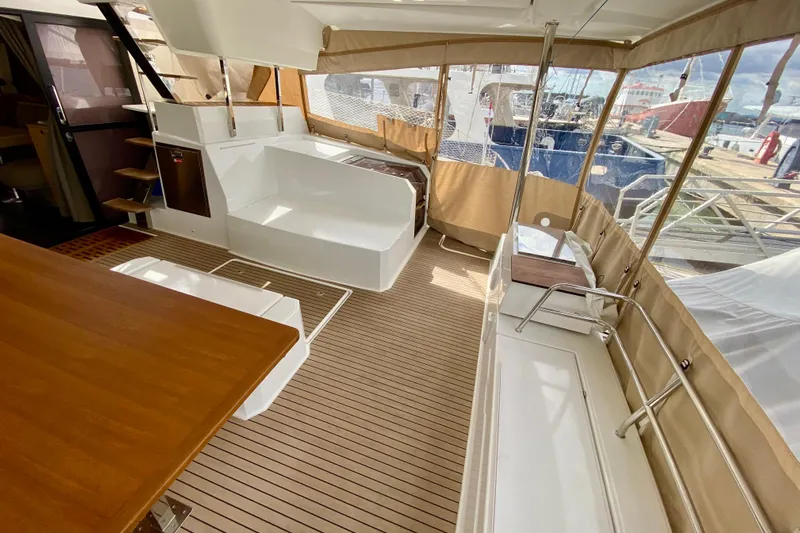  Yacht Photos Pics 2024 Fountaine Pajot Catamaran Aura 51 interior with wood flooring and seating area.