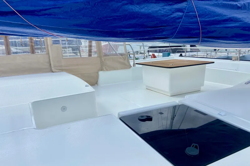  Yacht Photos Pics 2024 Fountaine Pajot Catamaran Aura 51 deck with blue canopy and seating area.