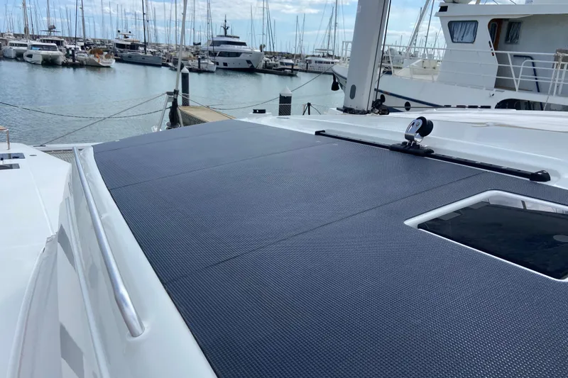 Yacht Photos Pics 2024 Fountaine Pajot Catamaran Aura 51 docked in a marina, showcasing sleek deck design.