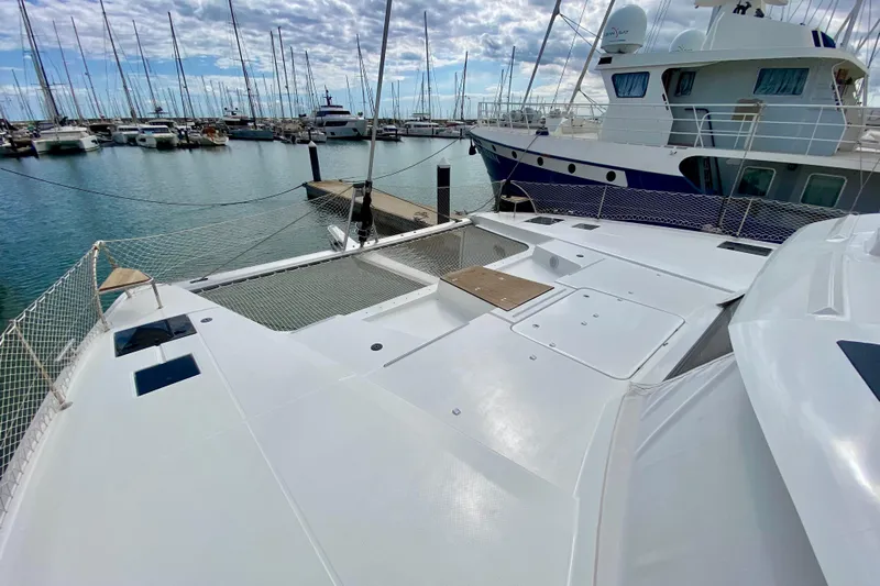  Yacht Photos Pics 2024 Fountaine Pajot Catamaran Aura 51 docked in a marina, showcasing spacious deck.