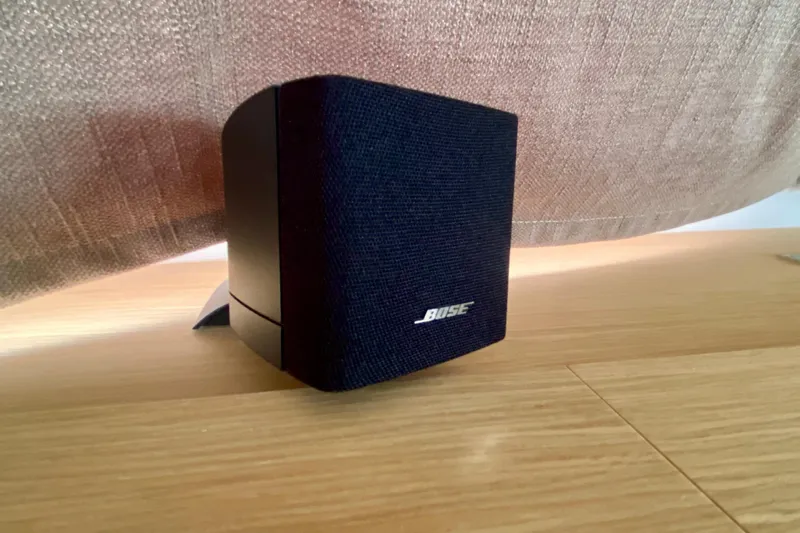  Yacht Photos Pics A Bose speaker on a wooden surface, partially covered by a curtain.