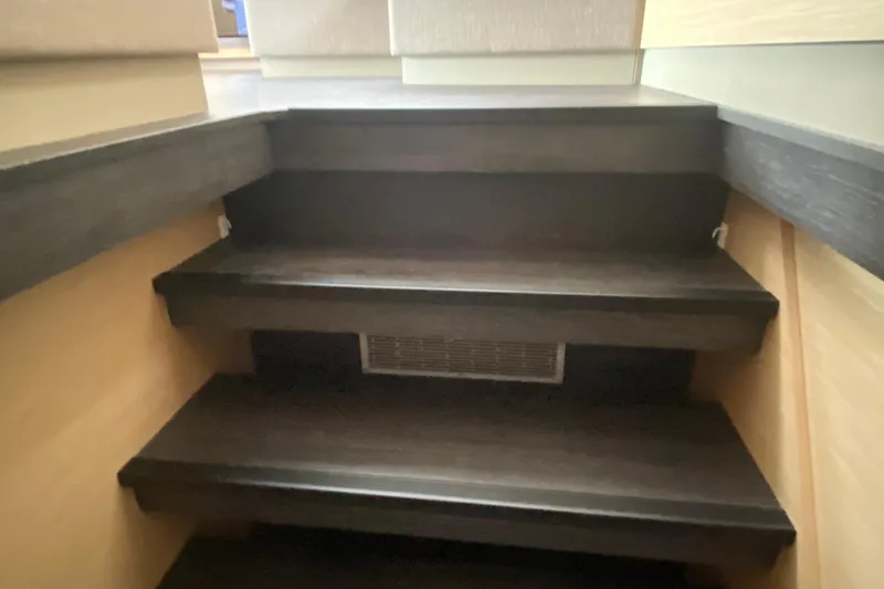  Yacht Photos Pics Interior stairs of 2024 Fountaine Pajot Catamaran Aura 51, featuring dark wood finish.
