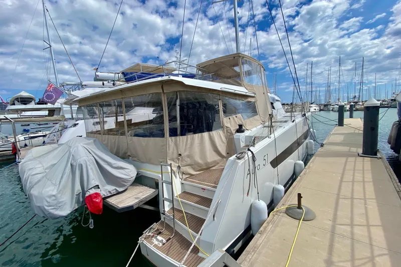  Yacht Photos Pics 2024 Fountaine Pajot Catamaran Aura 51 docked at marina under cloudy sky.