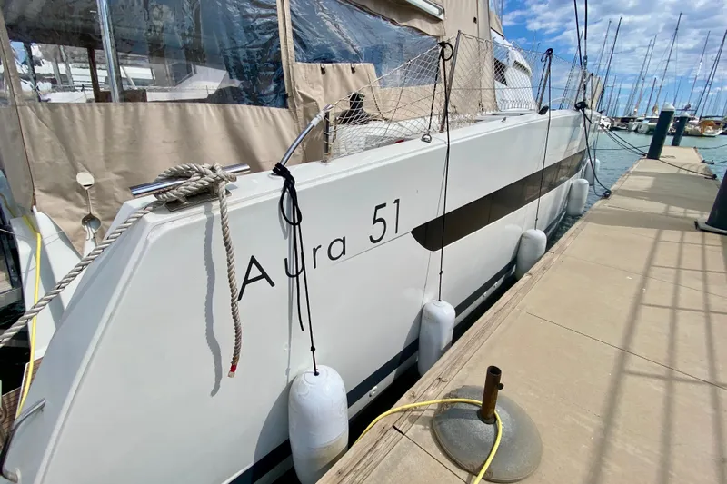  Yacht Photos Pics 2024 Fountaine Pajot Catamaran Aura 51 docked at marina, side view.