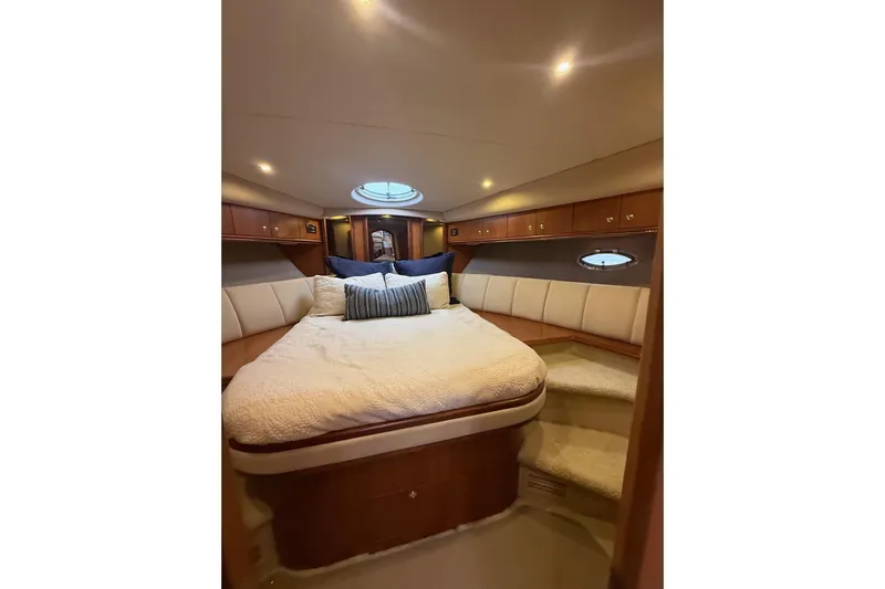 Cavu Yacht Photos Pics Luxurious cabin interior of 2001 Cruisers 4450 ACMY yacht with cozy bed and ambient lighting.