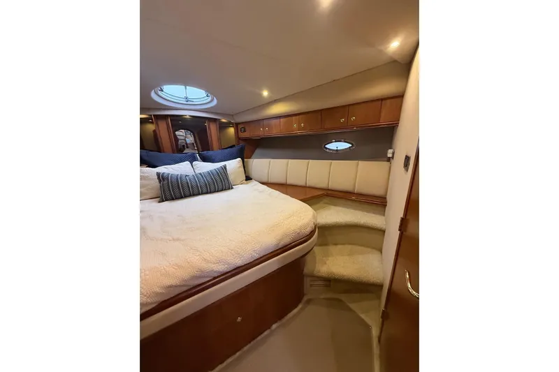 Cavu Yacht Photos Pics Luxurious cabin interior of 2001 Cruisers 4450 ACMY yacht with cozy bed and elegant wood finish.