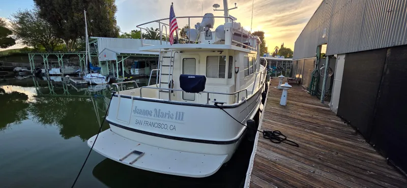 Jeanne Marie III Yacht Photos Pics 2003 Nordic Tug 42 docked at marina, San Francisco, with American flag.