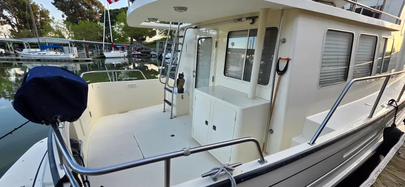 Jeanne Marie III Yacht Photos Pics 2003 Nordic Tug 42 docked, showcasing spacious deck and cabin area.