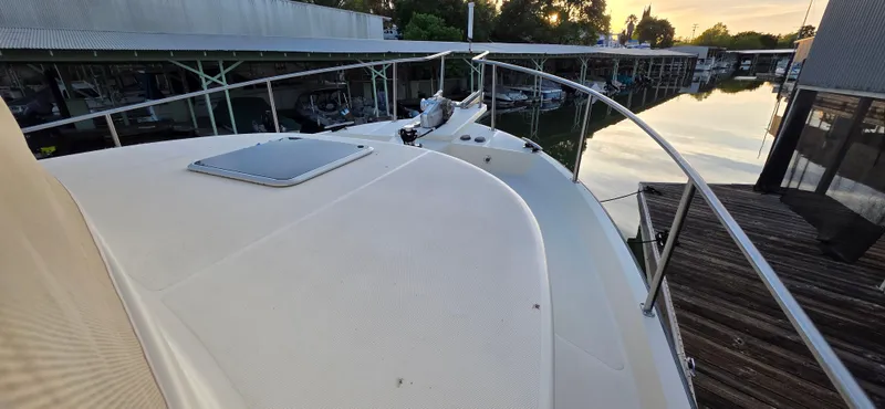 Jeanne Marie III Yacht Photos Pics 2003 Nordic Tug 42 boat deck with railing, docked at marina during sunset.