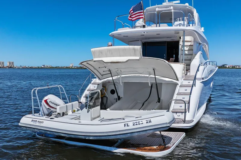  Yacht Photos Pics Luxury Lazzara yacht with tender boat, American flag, and scenic waterfront view.