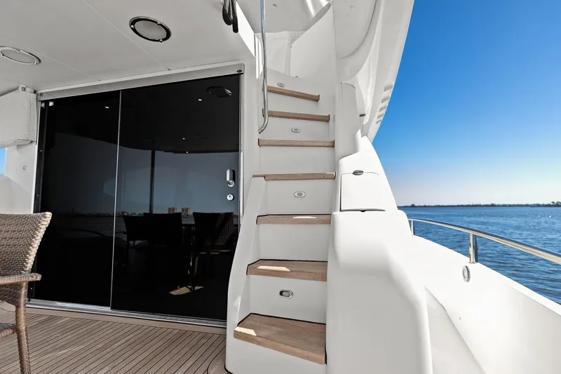  Yacht Photos Pics Luxury yacht deck with wooden stairs, glass doors, and ocean view. Lazzara make.