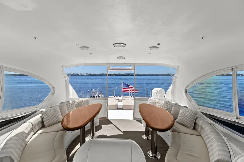  Yacht Photos Pics Luxurious Lazzara yacht interior with elegant seating, wooden tables, and ocean view.