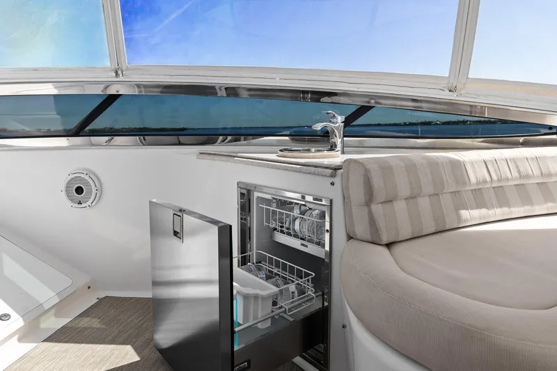  Yacht Photos Pics Luxurious Lazzara yacht interior with dishwasher, sink, and cushioned seating under a clear blue sky.