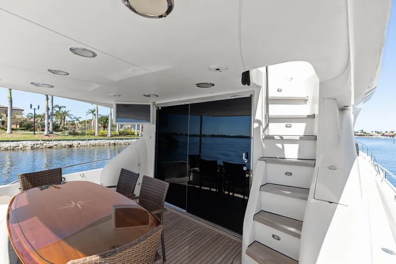  Yacht Photos Pics Luxurious Lazzara yacht deck with dining area, stairs, and waterfront view.