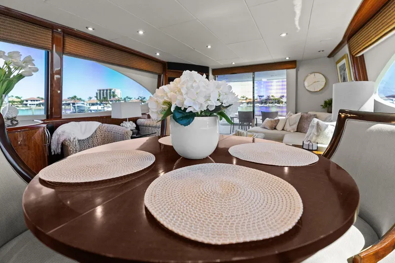  Yacht Photos Pics Luxurious Lazzara yacht interior with elegant dining area, floral centerpiece, and scenic window views.